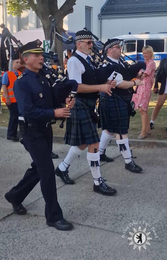 Die Piper der Band spielen beim MArschieren, im Vordergrund der Pipe Major und stv. Polizeipräsident